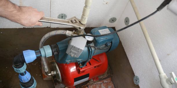 Contractor installing and repairing water pumping station. Borehole water pump.